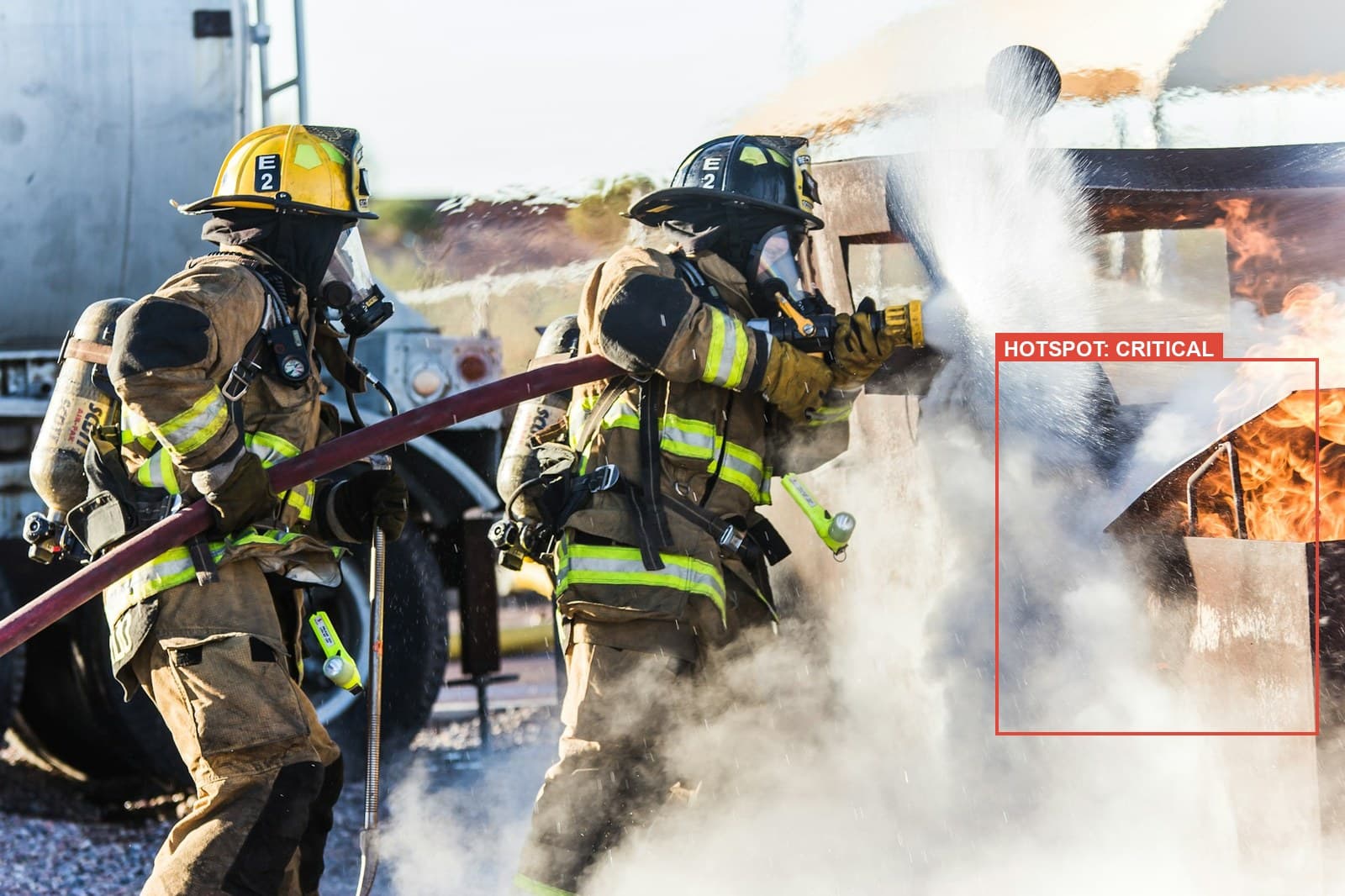 Firefighters battling a structure fire, annotated with a critical hotspot zone